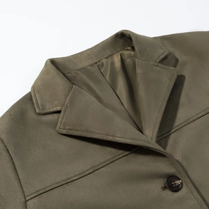 Detail of olive green suede blazer showing notched lapel, silk lining and textured button