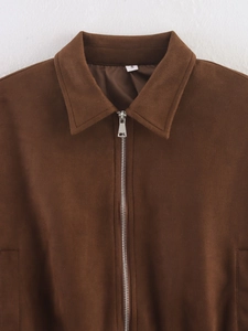 Dettaglio di una giacca in finto scamosciato marrone con zip argentata ed etichetta taglia S