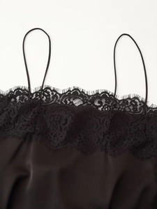 Close-up of black satin camisole featuring delicate eyelash lace trim and thin straps