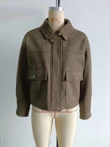 Detail view of olive brown suede jacket with large flap pockets and metal snap buttons