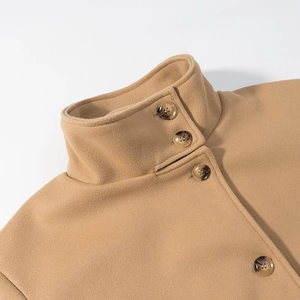 Detail of camel wool coat featuring a stand collar and textured amber buttons