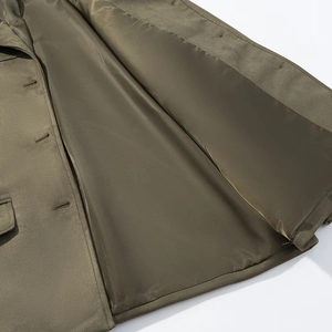 Detail of olive green suede blazer showing smooth silk lining and precise buttonhole stitching