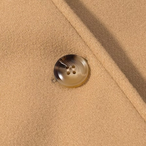 Detail of camel wool coat fabric with high-quality tortoiseshell pattern button