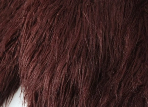 Détail rapproché de la texture en fausse fourrure douce d'un manteau d'hiver bordeaux