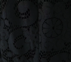 Close-up of black hollow-out lace fabric featuring intricate geometric floral patterns