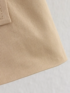 Détail du tissu sergé kaki avec coutures précises sur une veste courte de type trench