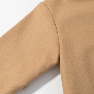 Detailed view of camel wool coat stitching and high-quality fabric texture on the sleeve
