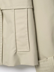 Close-up of khaki double-breasted trench coat with twill texture and precision stitching