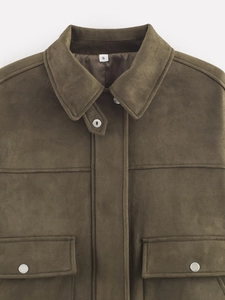 Detail of dark olive suede jacket showing metallic buttons and flap pocket texture