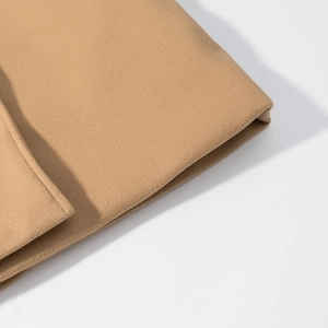 Macro shot of camel wool fabric showing premium texture and neat stitching on a coat