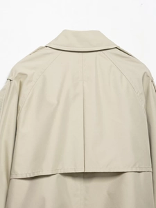 Detail of the storm flap and epaulets on the back of a classic beige trench coat