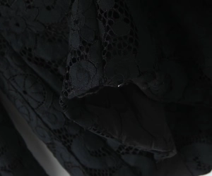 Close-up of black floral lace fabric with intricate hollow-out texture and inner lining