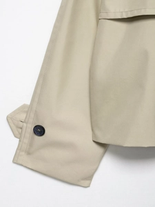 Detailed macro view of khaki trench coat cuff with button and twill fabric texture