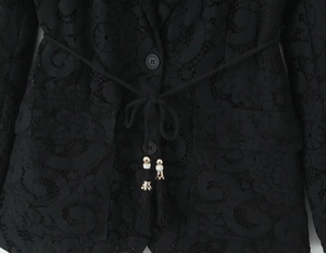 Detail of black floral lace blazer with drawstring waist and gold metal tassel accents