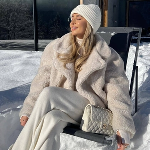 Plush white faux fur winter coat with lapels and warm long sleeves for cold weather