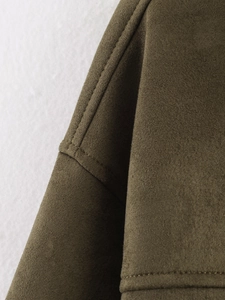 Macro shot of olive green suede jacket shoulder featuring precise double-needle stitching