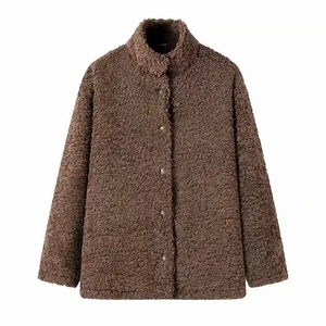 Detail of dark brown faux shearling jacket showing stand collar and metal button texture