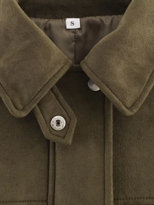 Detail of faux suede jacket showing olive green collar and silver metal snap buttons