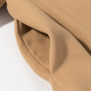 Macro view of camel wool coat side pocket showing premium fabric texture and stitching
