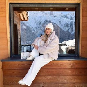 Women stylish beige sherpa fleece jacket with lapel collar in a snowy mountain setting
