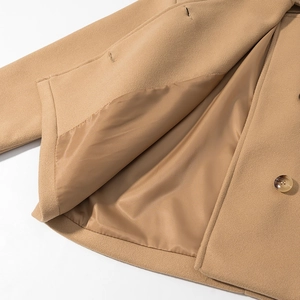 Detail view of khaki wool coat showing smooth silk lining and amber resin button texture