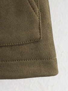 Macro view of olive green faux suede fabric showing detailed double-stitched pocket seams