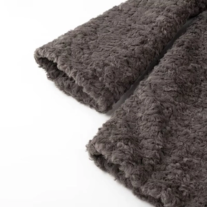 Detail of dark grey sherpa fleece fabric showing the thick curly texture of the coat sleeve