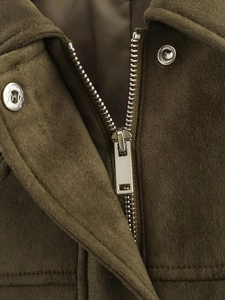 Detailed close-up of the silver metal zipper and soft army green suede fabric texture