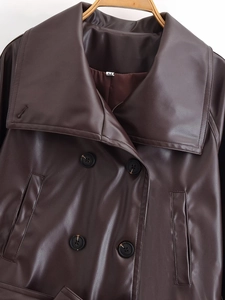 Detail of dark brown leather jacket with large lapels and double-breasted button design