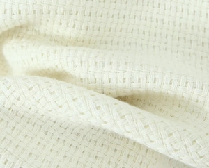 Detailed close-up of premium white woven tweed fabric texture on a long-sleeve jacket