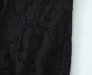 Close-up of intricate black hollow-out lace fabric with floral and geometric patterns