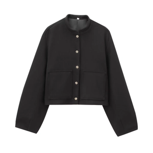 Detail view of a black bomber jacket featuring metallic buttons and large square pockets