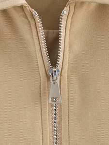 Detailed close-up of a silver rectangular hollow zipper on a khaki puffer jacket
