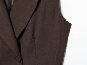 Macro detail of dark brown twill waistcoat featuring notched lapels and fabric buttons