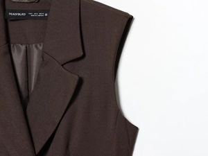 Detailed macro view of dark chocolate twill fabric texture and lapel on a vest suit