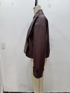Detail of dark mahogany PU leather jacket with button cuffs and elastic hemline