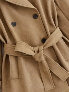 Detailed close-up of double-breasted camel suede trench coat with tied waist belt