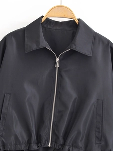 Detailansicht einer schwarzen kurzen Reißverschlussjacke mit Metall-Zipper und Taschen