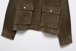 Close-up of suede jacket hem with large flap pockets and silver metal snap buttons