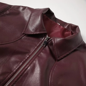 Macro detail of wine red leather jacket featuring turnover collar and metal zipper closure