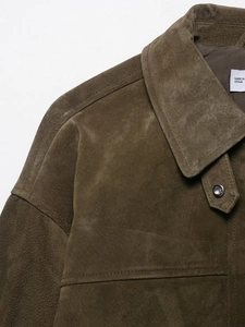 Detail of soft brown suede jacket showing lapel collar, metal button and fine stitching