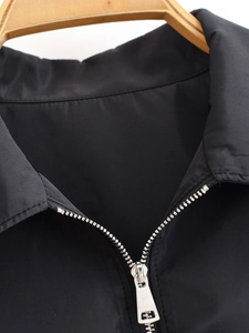 Detail der schwarzen Reißverschlussjacke mit Silberreißverschluss und ordentlicher Naht am Bügel