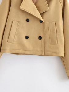 Detail of khaki double-breasted short trench coat with notched lapels and soft texture