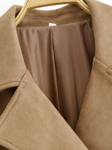 Close-up of brown suede jacket collar with soft texture and smooth inner lining detail