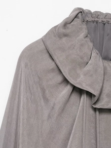 Detail view of ruffled neckline and pleated collar on mauve silk-textured jacket