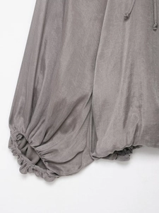 Detail of grey bomber jacket showing elastic cuff and delicate drawstring texture