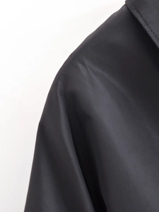 Detailansicht der Schulter und des Ausschnitts einer schwarzen Kordelzug-Jacke