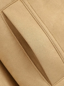 Detail of camel suede jacket showing fine stitching and soft fabric texture closeup