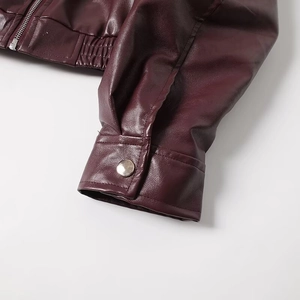 Detail of burgundy PU jacket featuring silver snap button cuff and smooth metal zipper