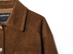 Detailed view of the dark brown corduroy texture and brand label on the vintage jacket